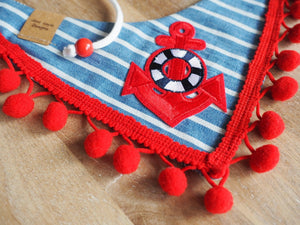 Detailansicht gestreiftes Hundehalstuch mit rotem Anker und roter Bommelborte