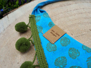 Detailansicht Hundehalstuch und Katzenhalstuch mit Blattmuster und grüner Bommelborte